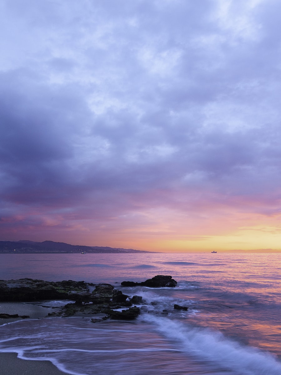 A dreamlike pastel sky over a still sea