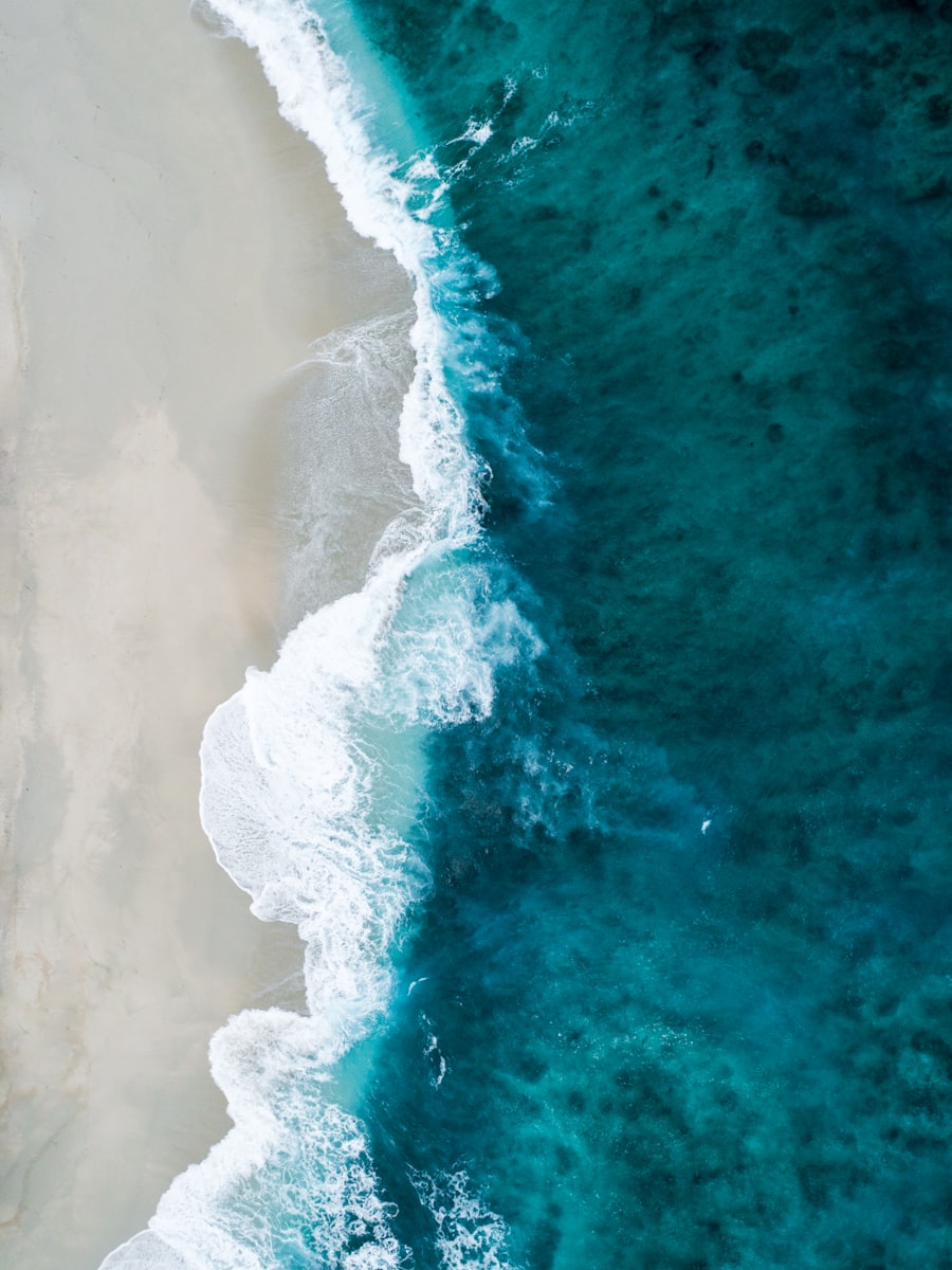 An aerial view of surf meeting a sandy shore