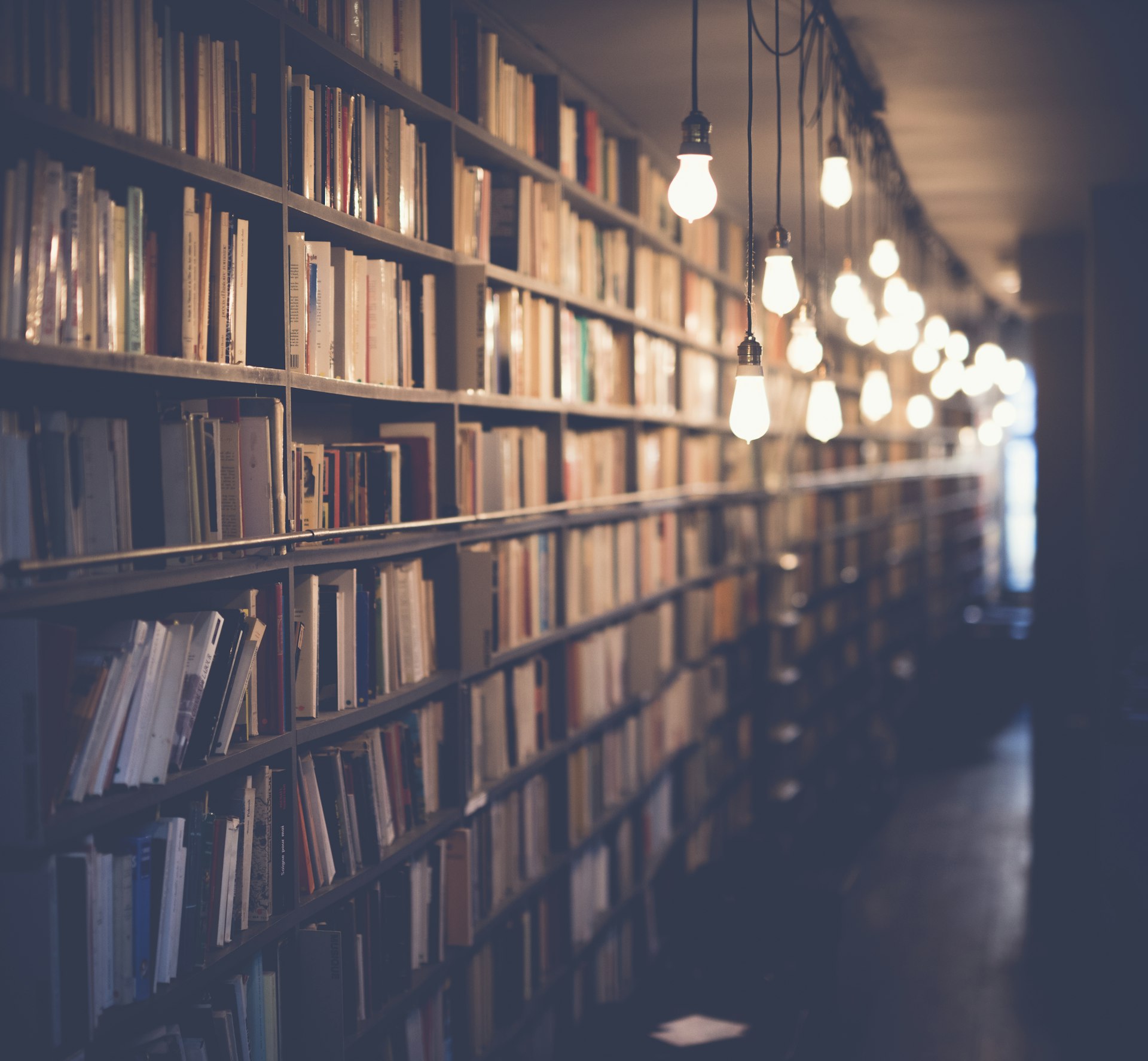 Shelves of old books in a dim library