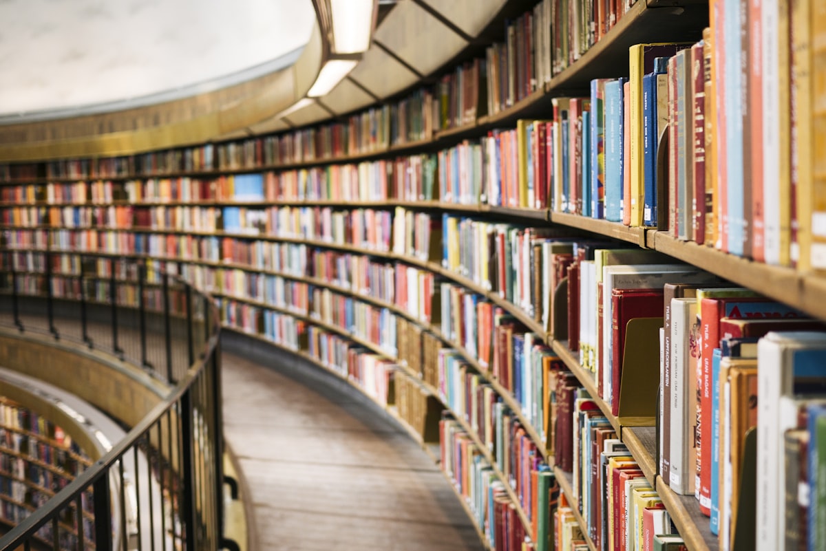 A sweeping curved shelf of books in a library